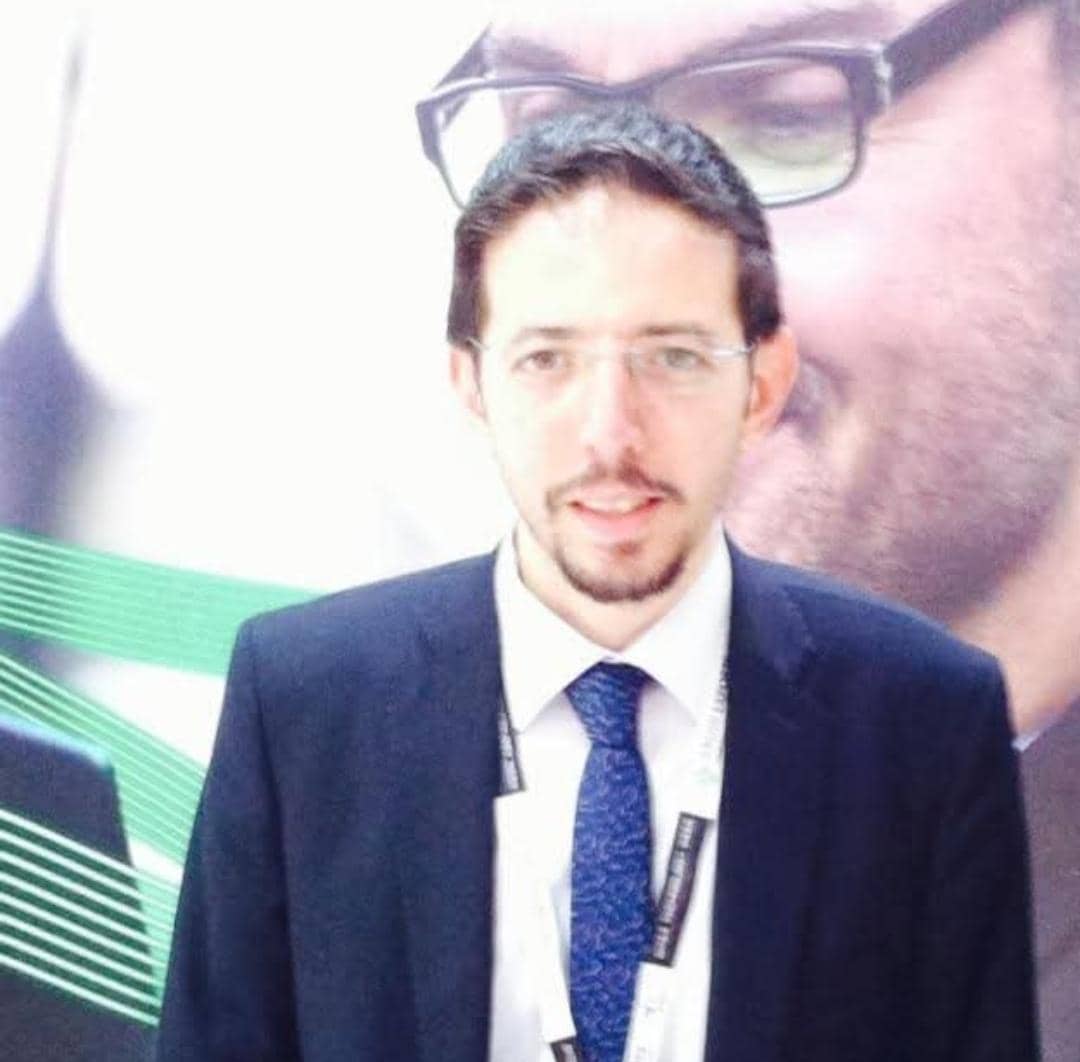 professional headshot of middle eastern business executive, confident expression, formal suit, finance background